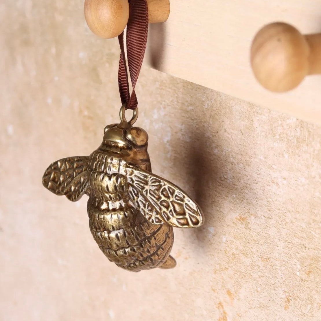 Brass bee-shaped hanging decoration.