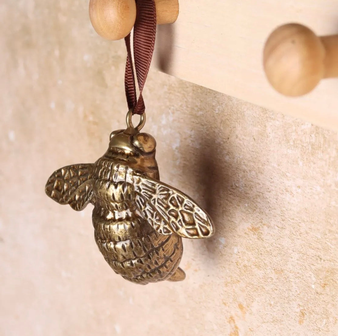 Brass bee-shaped hanging decoration.