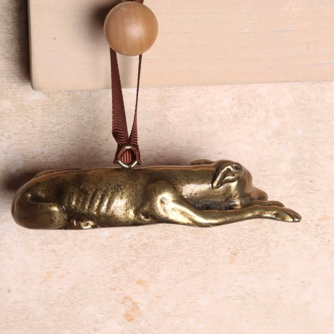 Brass hanging Greyhound-shaped ornament.