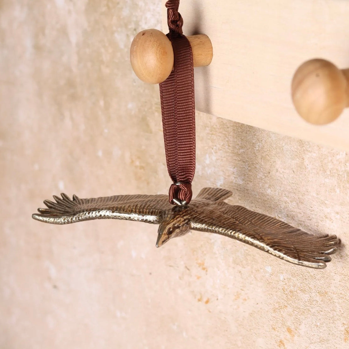 Brass buzzard-shaped hanging Christmas decoration.