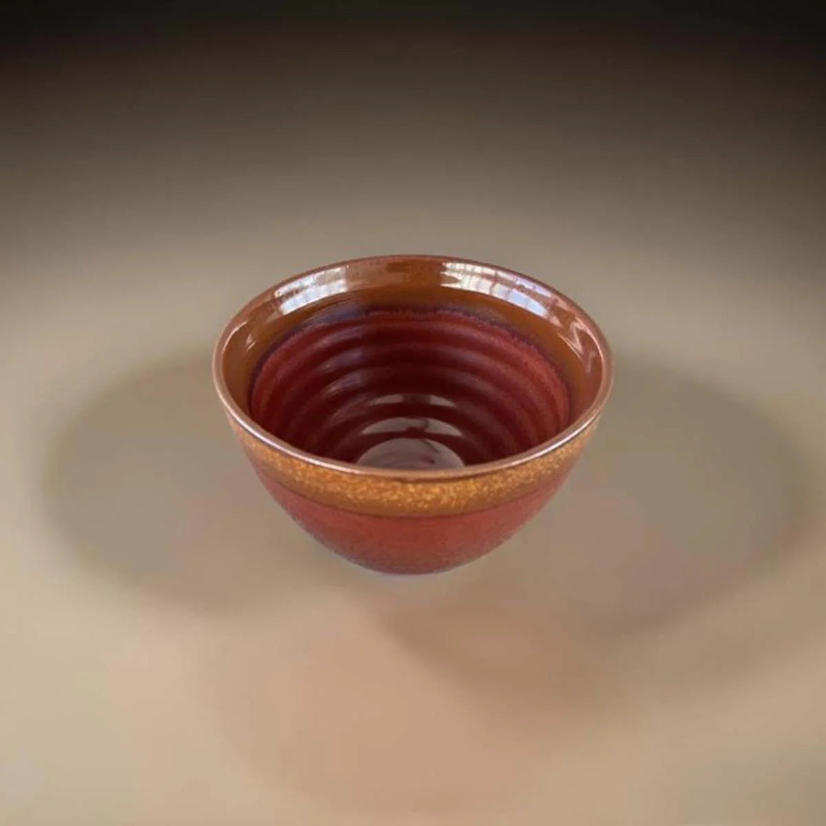 Rust coloured ceramic bowl with brown edge.
