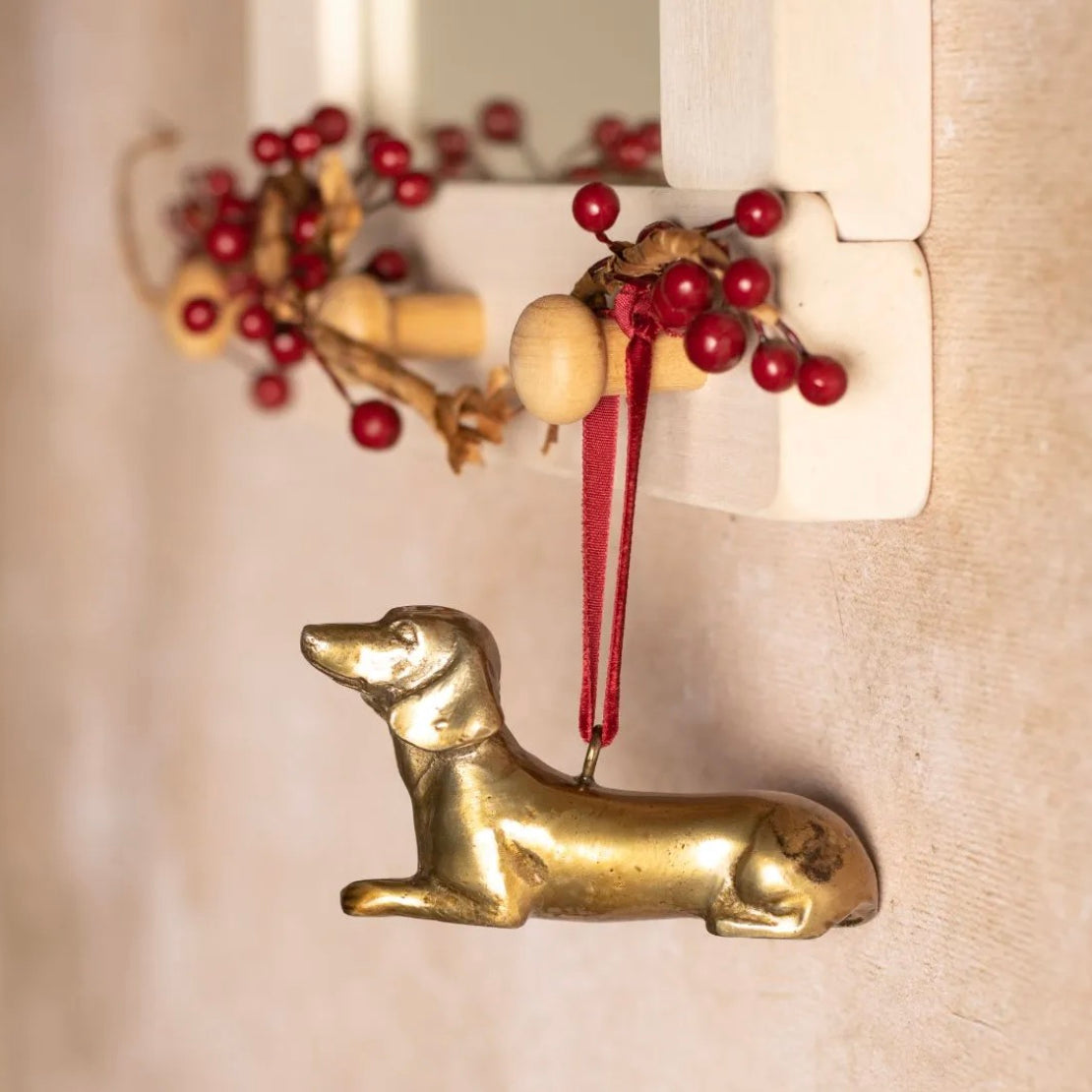 Brass Dachshund-shaped hanging Christmas decoration.