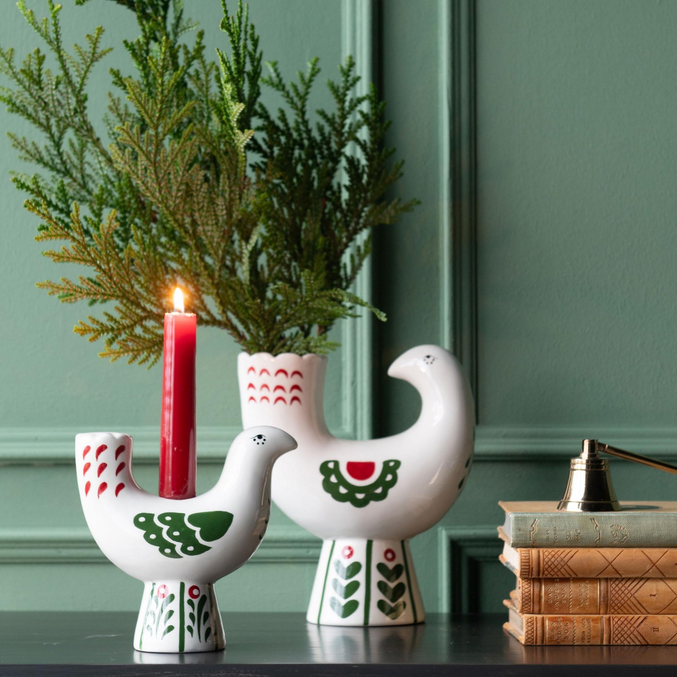 White bird Christmas candle holder with red and green decoration.