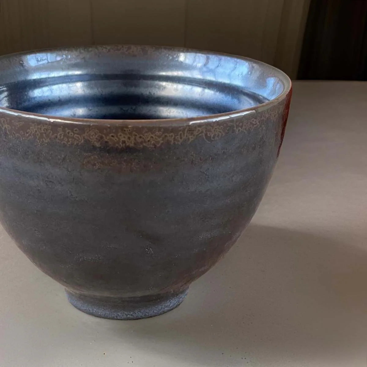 Graphite ceramic bowl with speckled glaze.
