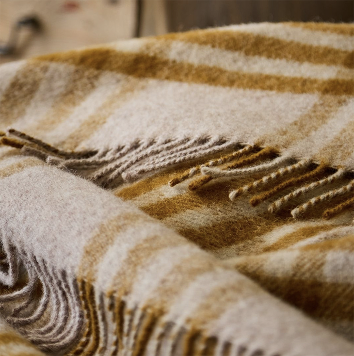 Close-up of a plaid blanket with English mustard and oatmeal colours.