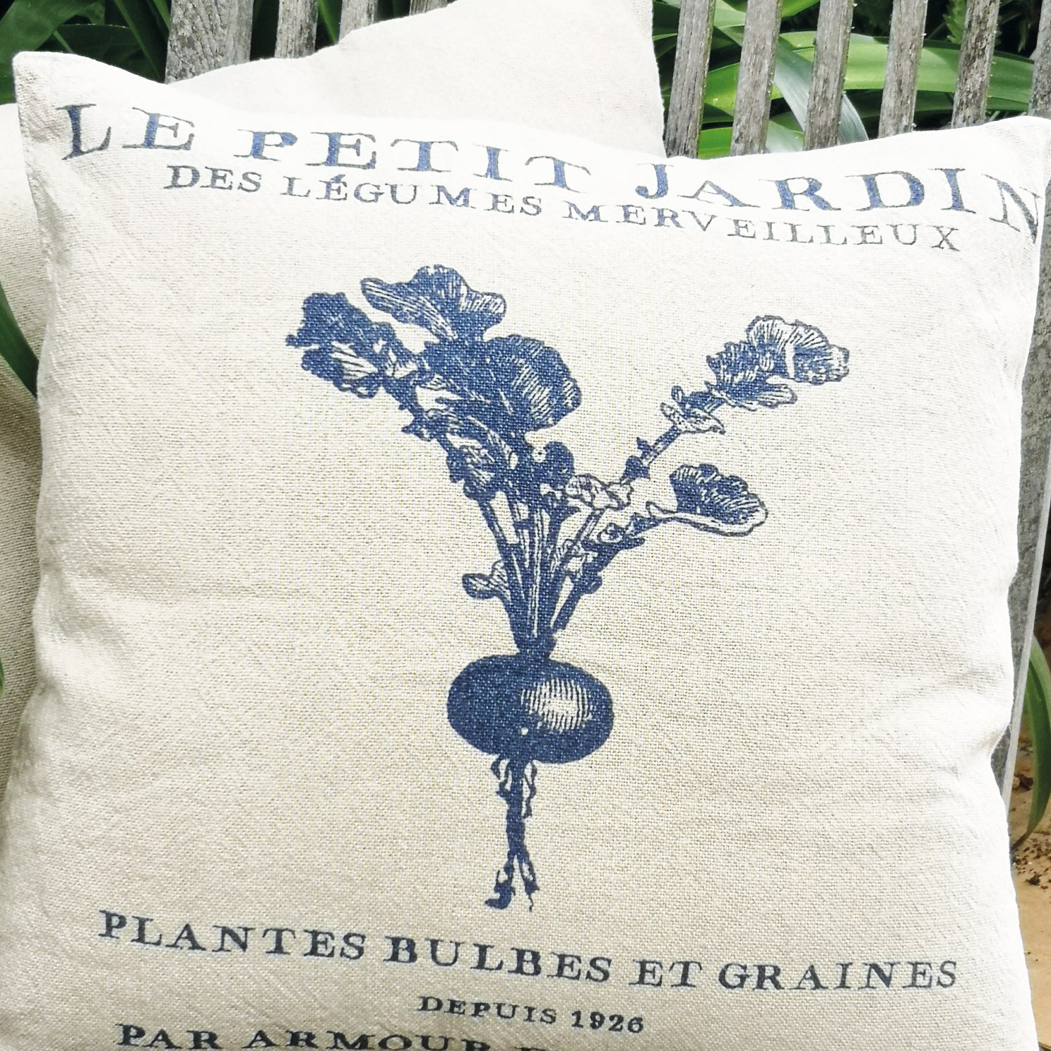 Decorative pillow with vintage-style design featuring a radish and text on a wooden bench.