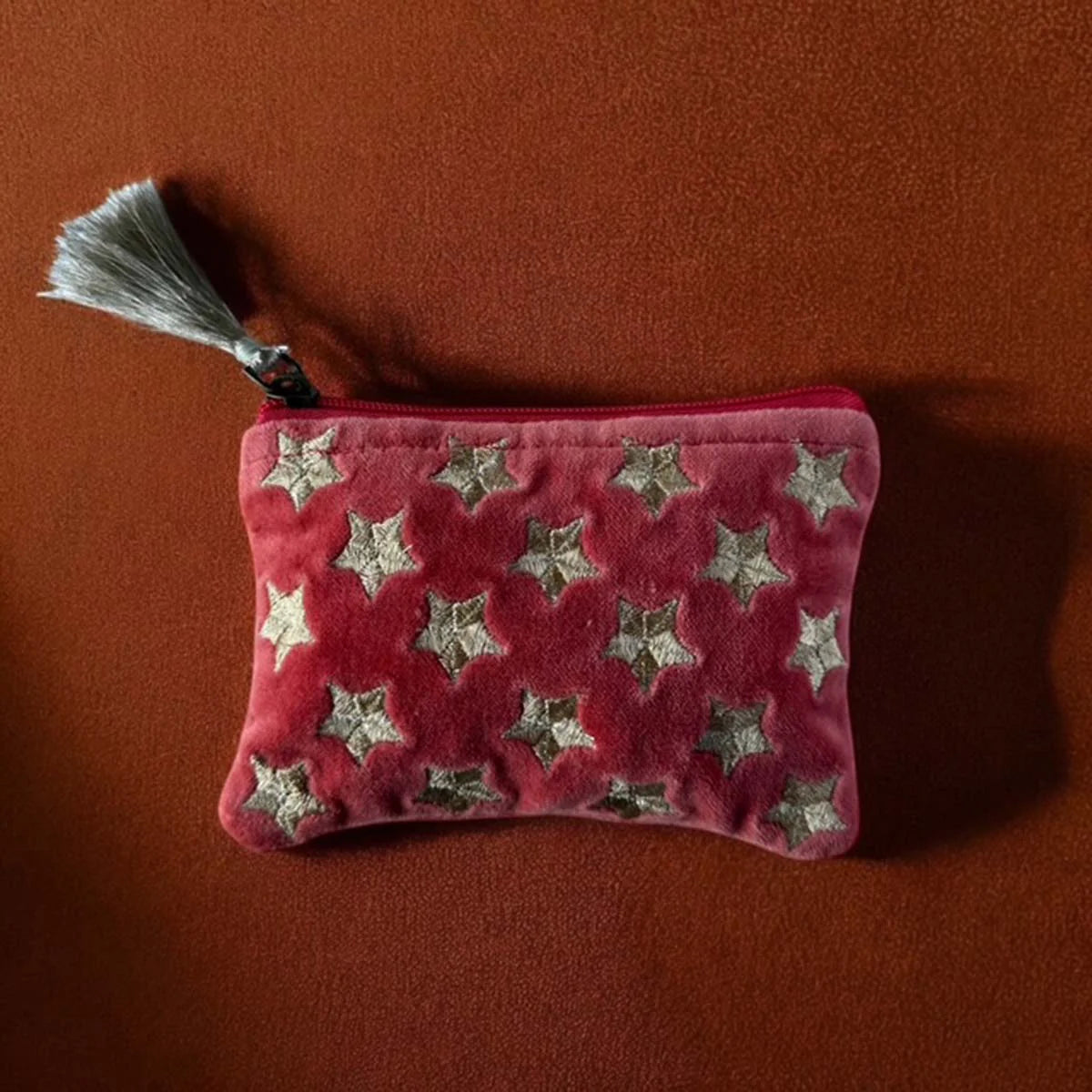Orange velvet pouch with gold star embroidery and tassel.