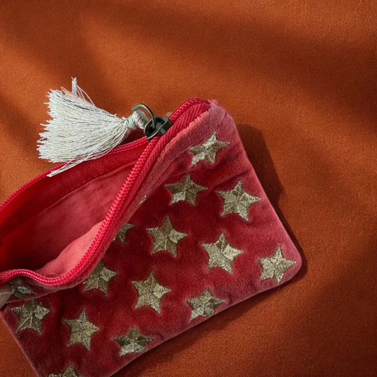 Orange velvet pouch with gold star embroidery and tassel.
