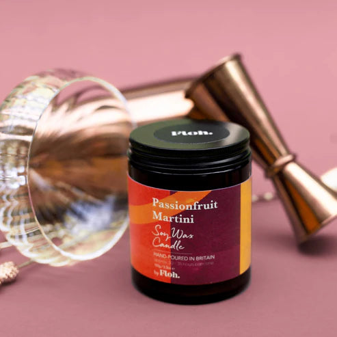 Candle jar labeled 'Passionfruit Martini' by Floh on a pink background