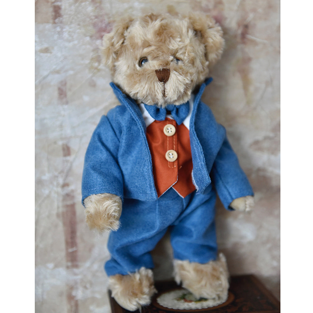 Teddy bear wearing a blue suit and red waistcoat.