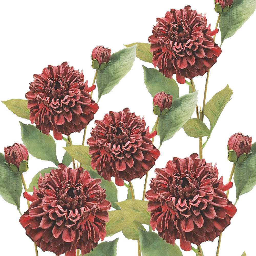 Faux red dahlias with green leaves on a white background