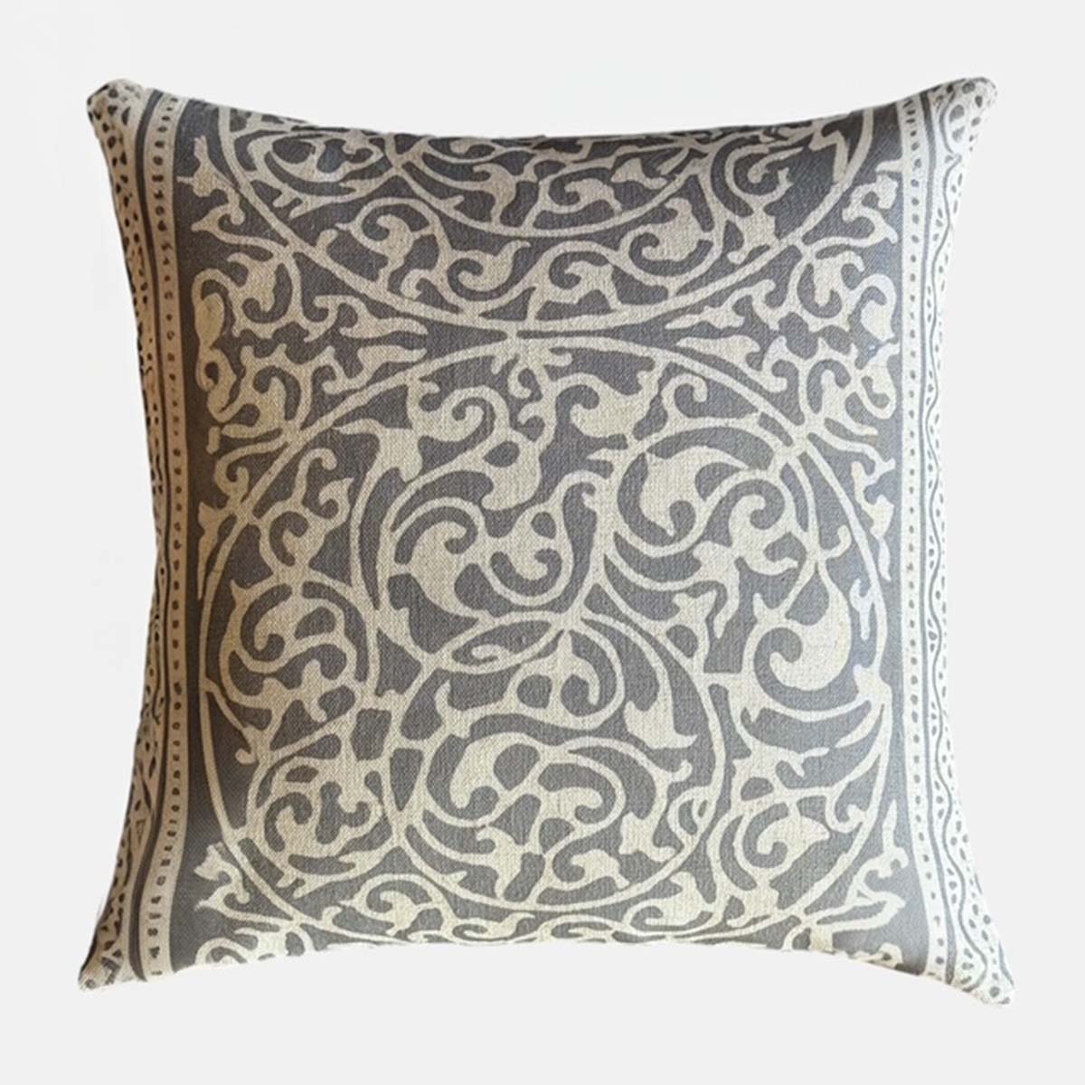 Decorative pillow with intricate fretwork pattern on a light gray background
