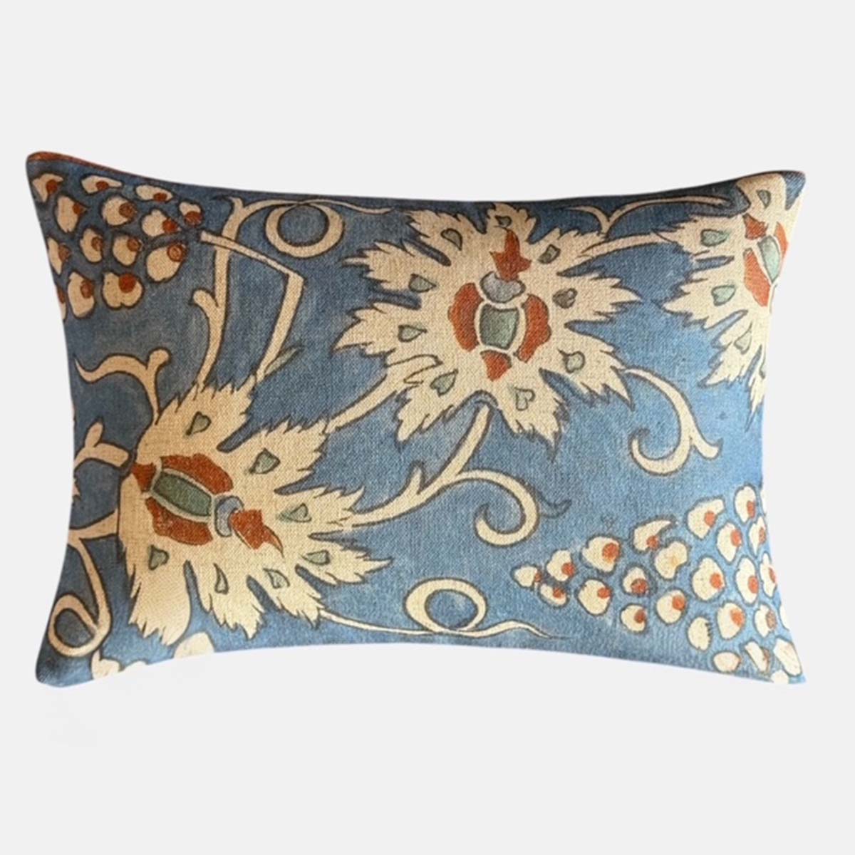 Decorative throw cushion with stone and rust coloured floral pattern on a blue background.