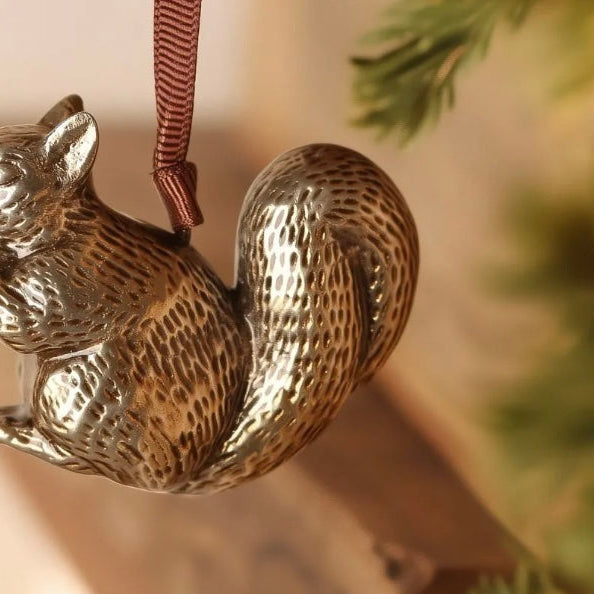 Brass squirrel-shaped hanging ornament.