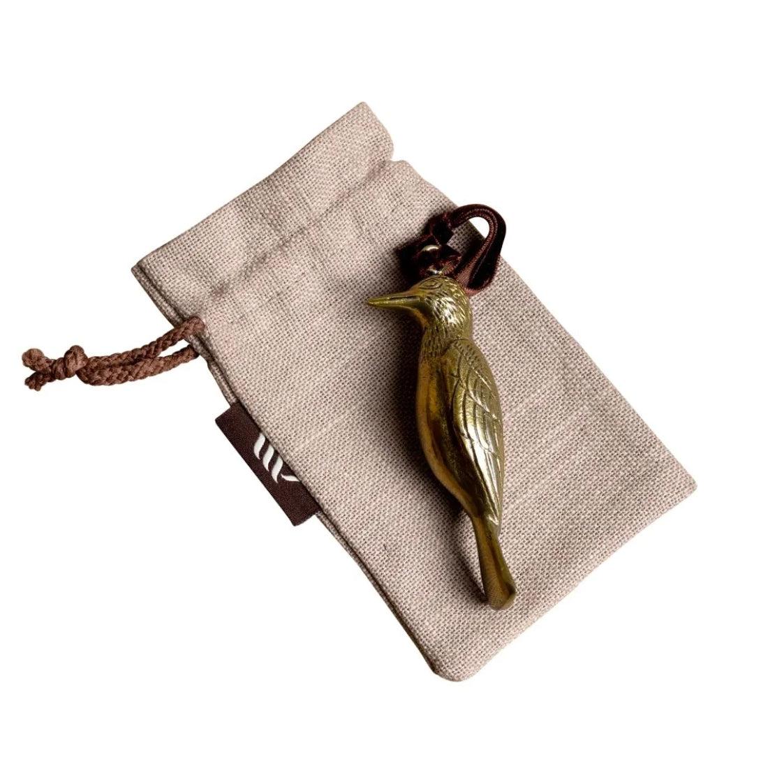 Brass woodpecker-shaped hanging ornament on linen gift bag.