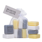 Set of six 25g triple milled  luxury soap bars in a voile bag with 'Branche d'Olive' label  and 6 bars scattered around with twig stamp on a white background