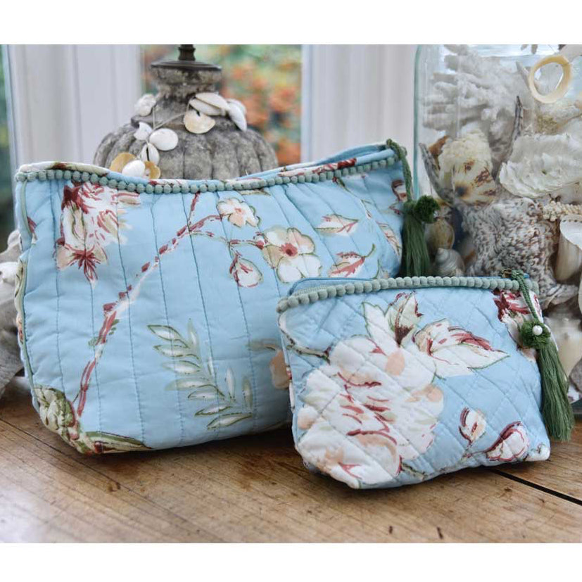 Blue wash bag with blossom print and green tassel.