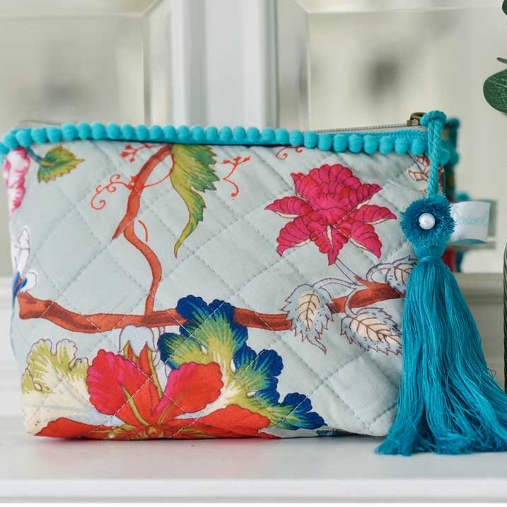 Blue floral print makeup bag with blue tassel.