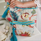 Blue floral print wash bag with blue tassel and blue edging.