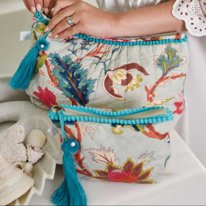 Blue floral print wash bag with blue tassel and blue edging.