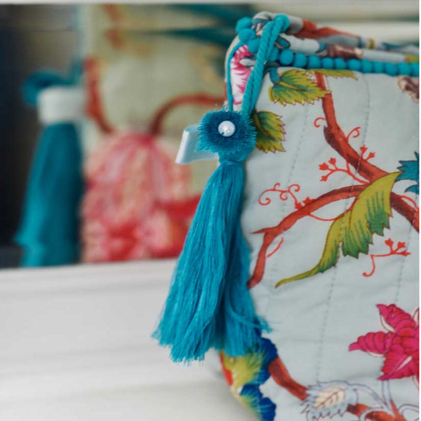 Blue floral print wash bag with blue tassel and blue edging.