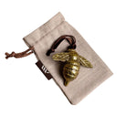 Brass bee-shaped hanging ornament on linen gift bag.