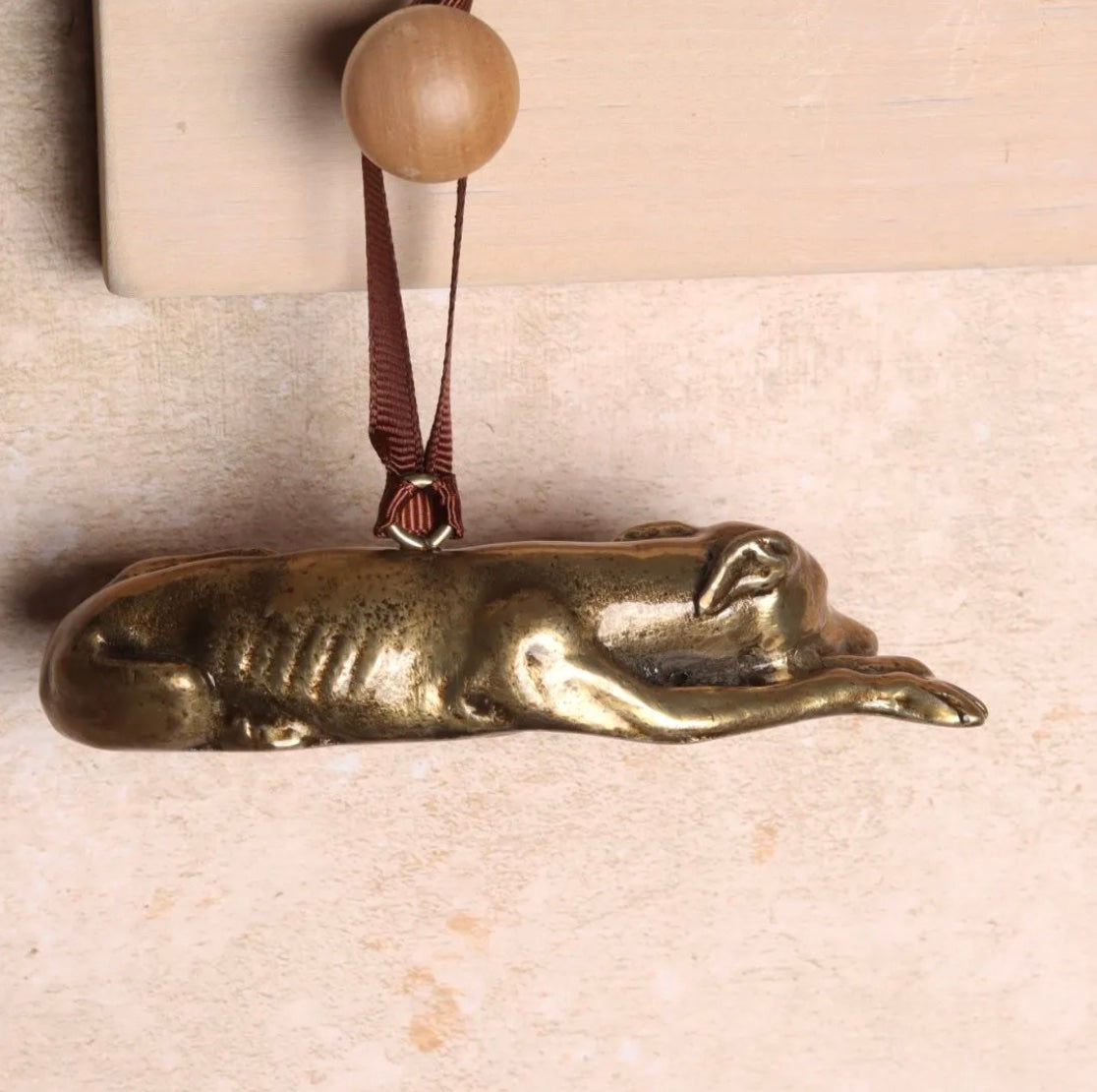 Brass hanging Greyhound-shaped ornament.