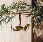 Brass otter-shaped hanging Christmas ornament.