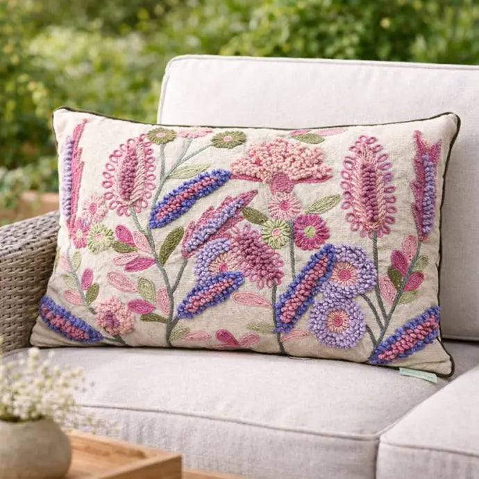 Decorative pillow with floral embroidery on a couch outdoors