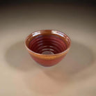 Rust coloured ceramic bowl with brown edge.