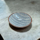 Ceramic plate with a blue geometric pattern on a white surface.