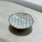 Ceramic plate with a blue dash pattern on a white surface.