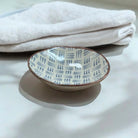 Ceramic plate with a blue dash pattern on a white surface.
