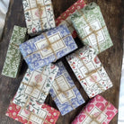 Collection of soap bars in decorative wrappers tied with jute string.