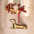 Brass Dachshund-shaped hanging Christmas decoration.