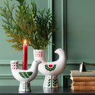 White bird Christmas candle holder with red and green decoration.