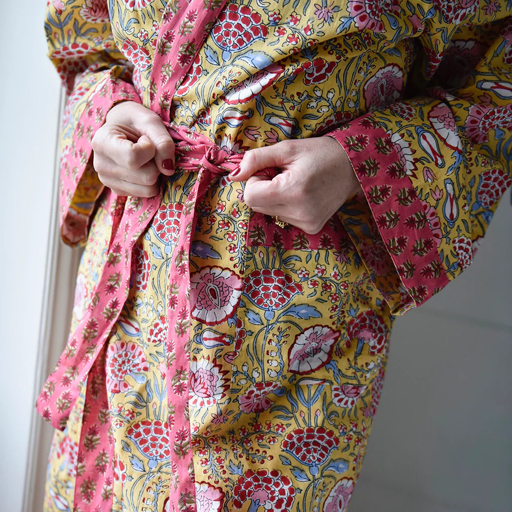 Person wearing a colorful floral robe with pink and yellow patterns.