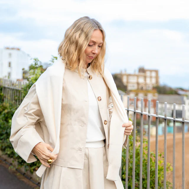 Woman wearing a cotton coat and dress outdoors with a blurred background