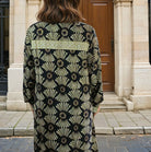 Patterned knee length shirt dress in black and gold.