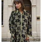 Patterned knee length shirt dress in black and gold.