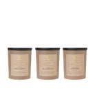 Trio of scented candles in brown jars in Vanilla Bergamot, Lush Magnolia and Grapefruit Ginger scents.