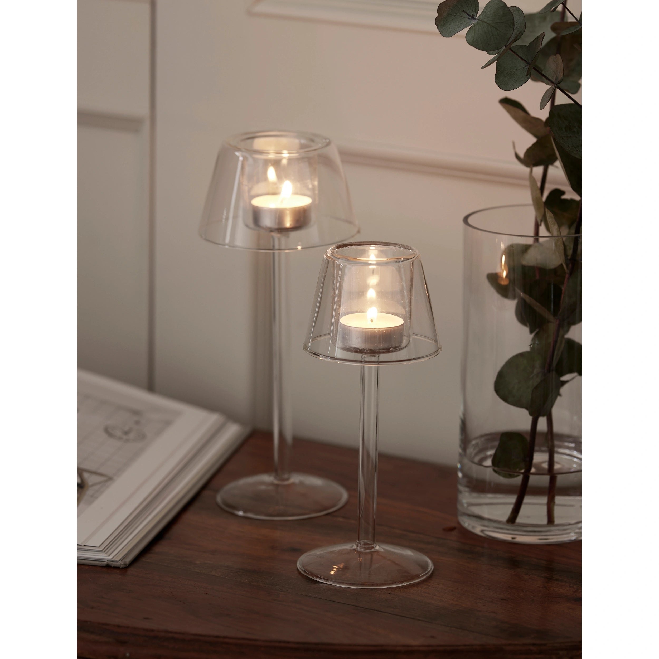 Iona clear glass lantern tea light holders with lit tea lights on a wooden table