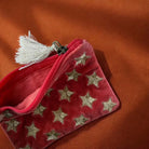 Orange velvet pouch with gold star embroidery and tassel.
