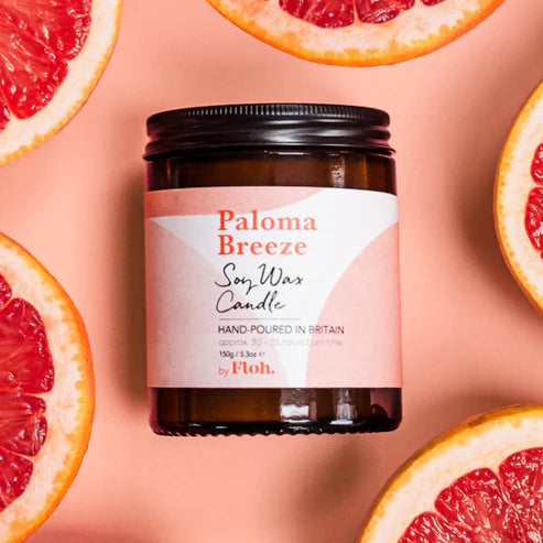 Paloma Breeze soy wax candle with grapefruit slices on a pink background