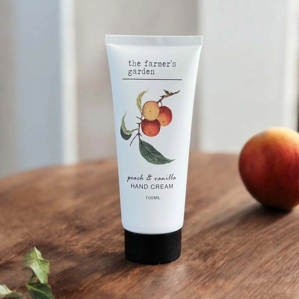 Hand cream tube labeled 'the farmer's garden' with a peach and vanilla scent.