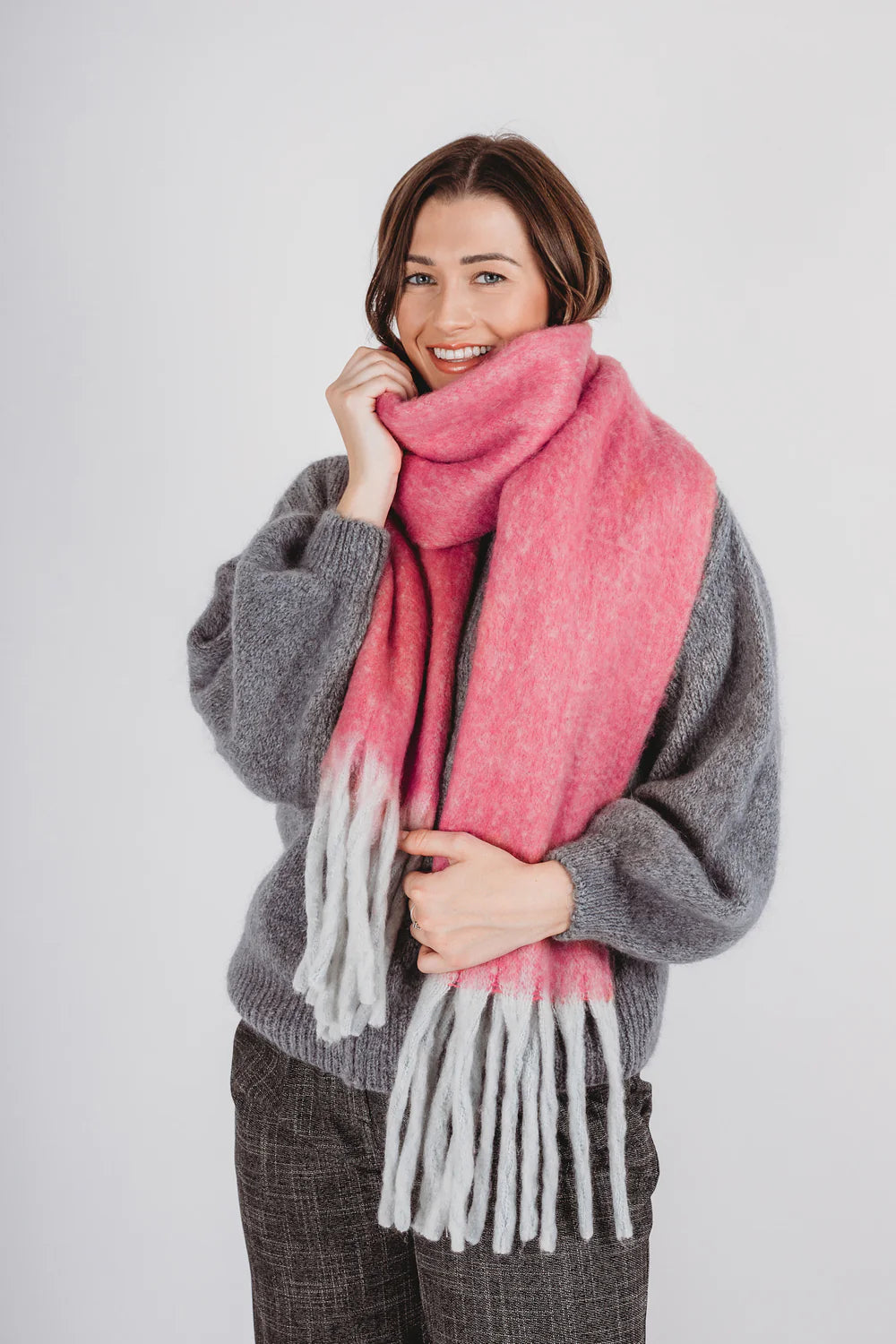 Pink winter scarf with white tassels.