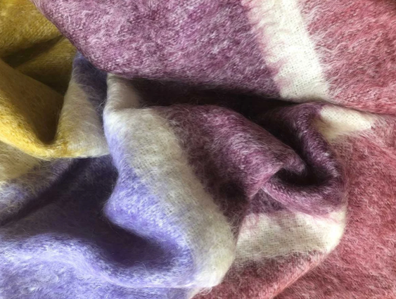 Detail of luxurious traditionally made Mohair Throw in Dusk Colours - burgundy, deep purple and ochre. Demonstrating its super softness.
