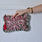Back damask print make up bag with ruffle trim lifesstyele against white tiled background