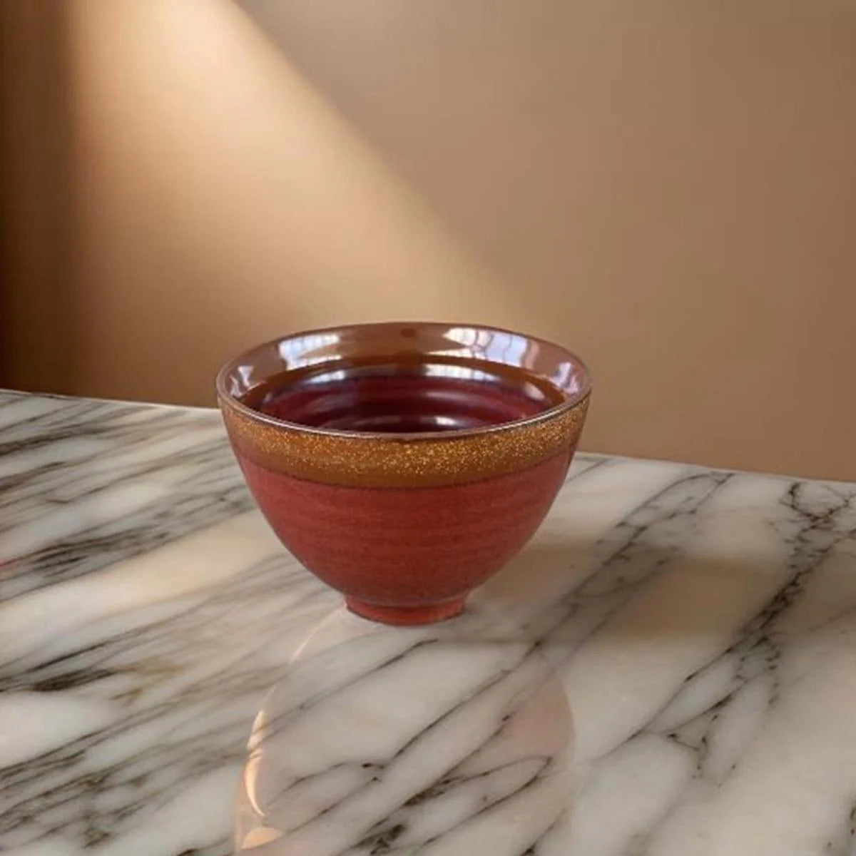 Rust coloured ceramic bowl with brown edge.