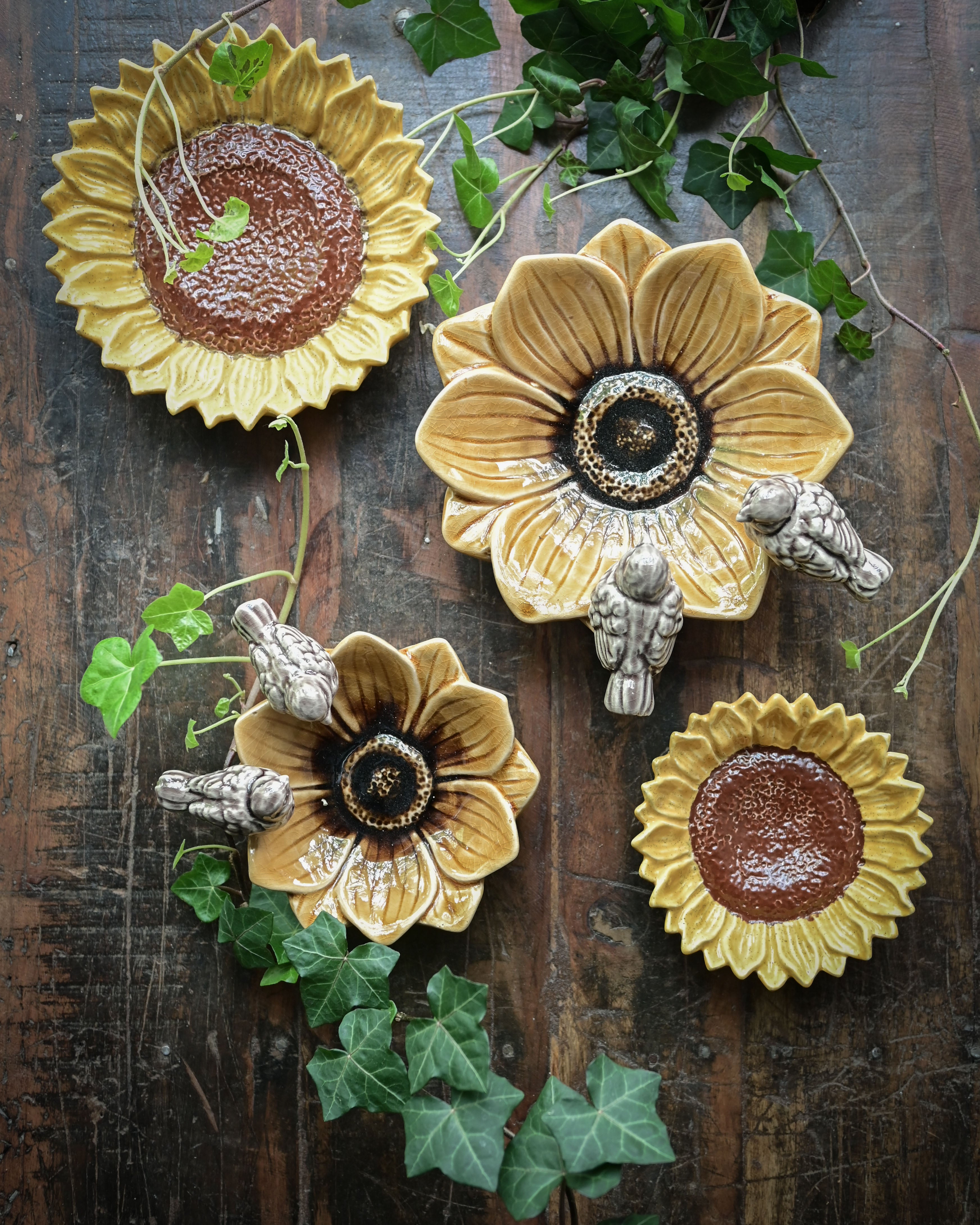 Decorative sunflower-shaped plates with floral designs on a wooden surface.